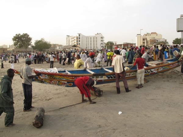 Men with pirogues at Dakar's Soumbedioune Market.